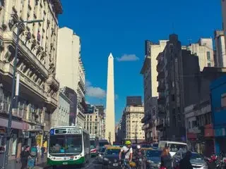 Vista de la Avenida 9 de Julio con el Obelisco y tráfico urbano en Buenos Aires.