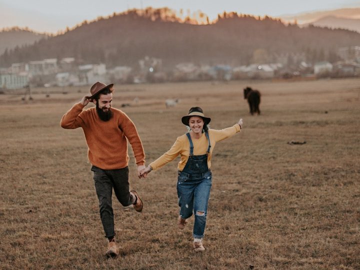Pareja corriendo en el campo sonriendo